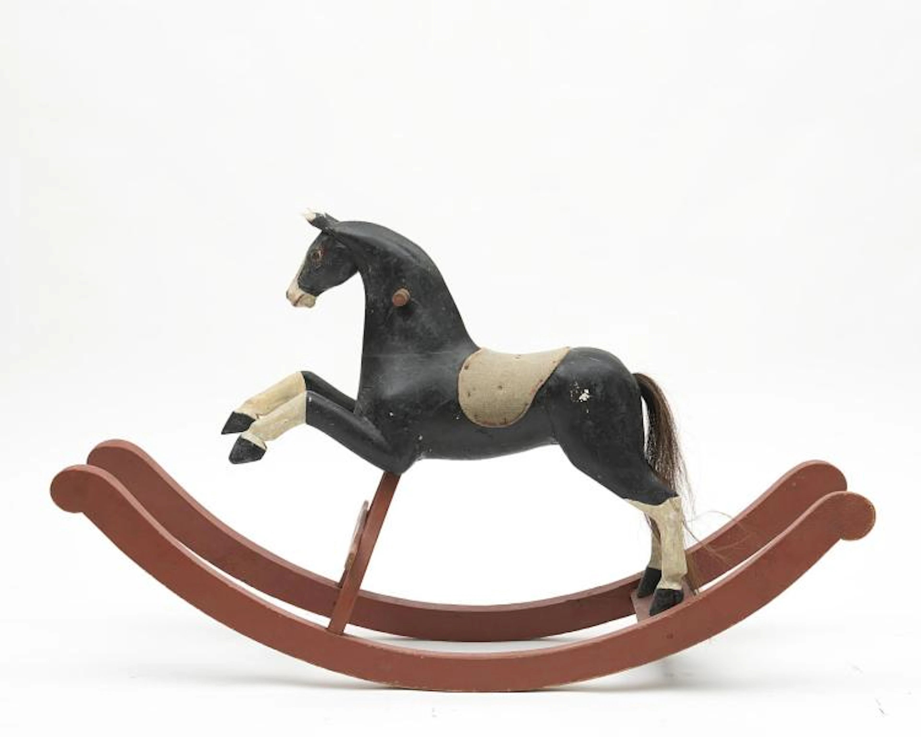 Cheval à bascule en bois peint, queue en crin, selle en tissu.