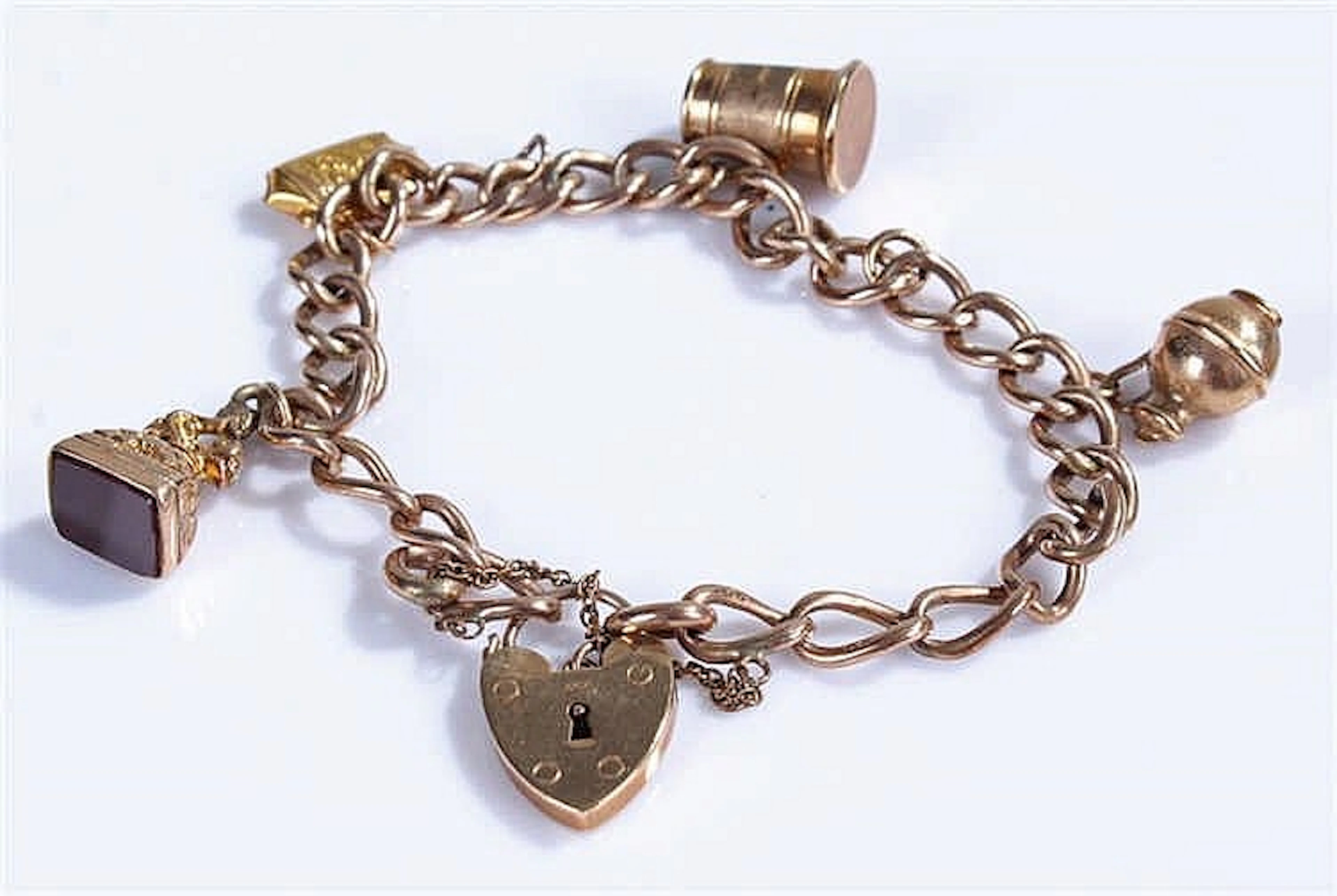 9 carat gold charm bracelet, with charms to include a tankard, bag, jug, et