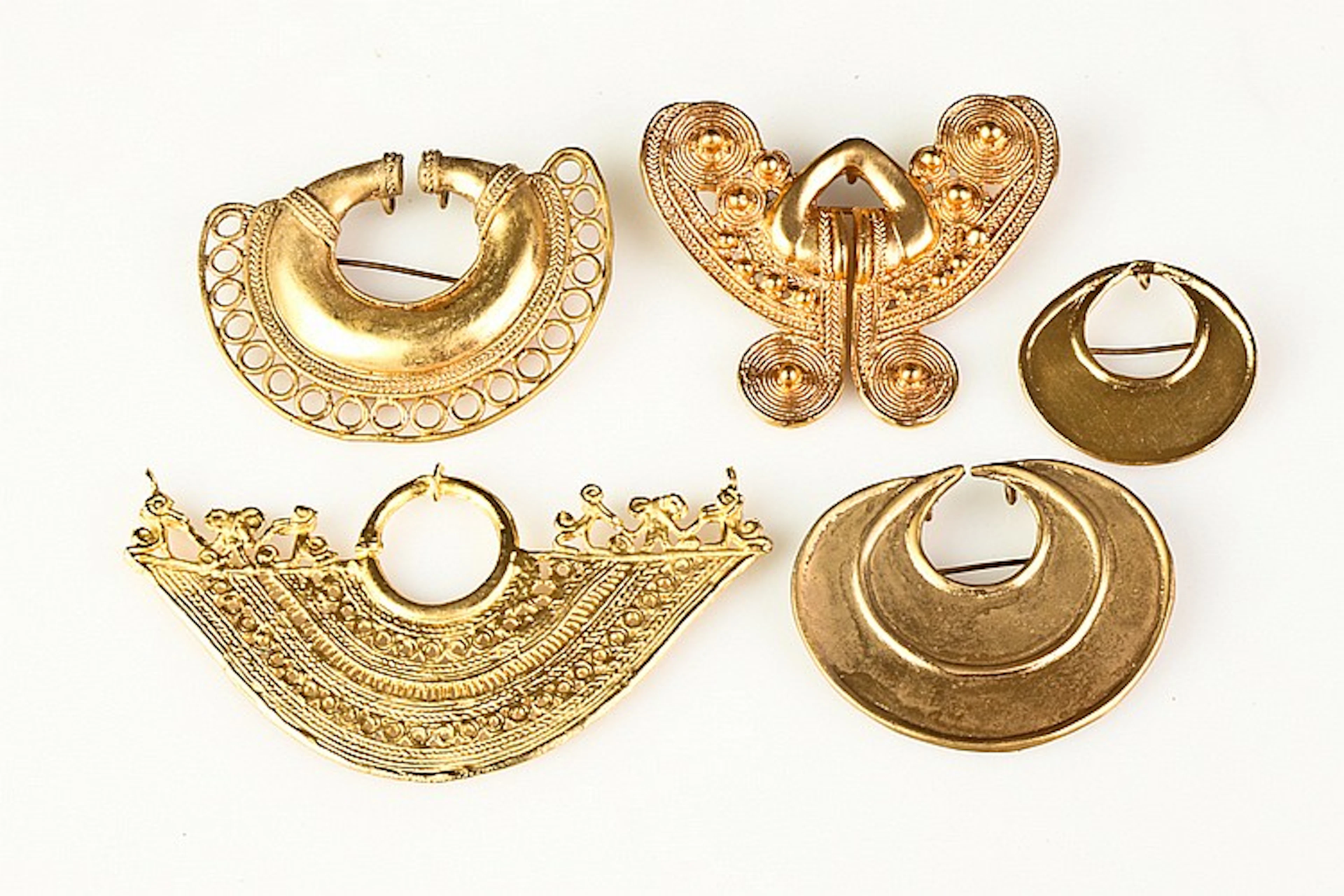 FIVE GOLD-TONE REPRODUCTION PRE-COLOMBIAN BROOCHES AND ORNAMENTS,