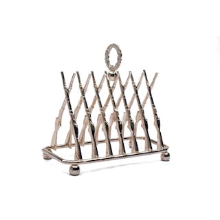 A LARGE SILVER TOAST RACK IN THE FORM OF CROSSED GUNS,