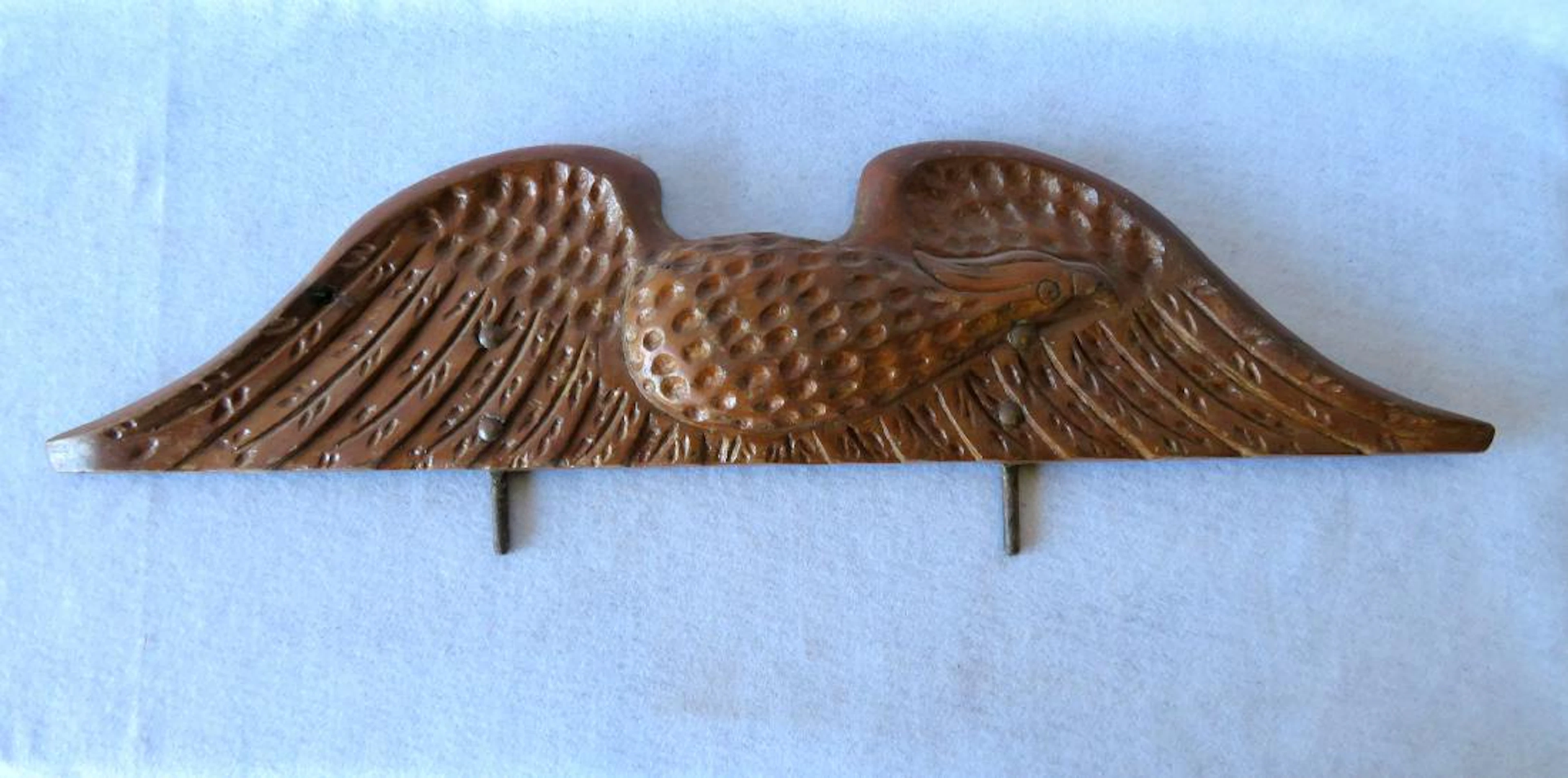 Hand carved wooden spread wing eagle wall plaque in an